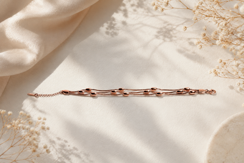 Serene Whispers: Triple-Strand Rose Gold Bead Bracelet